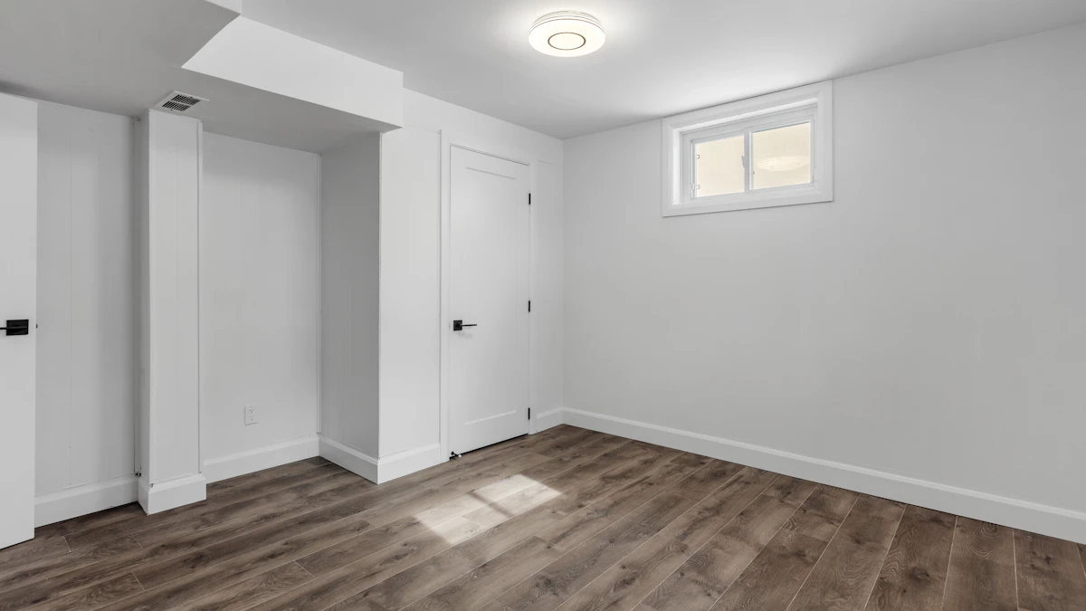 Finished basement room with dark wood-look flooring and white walls