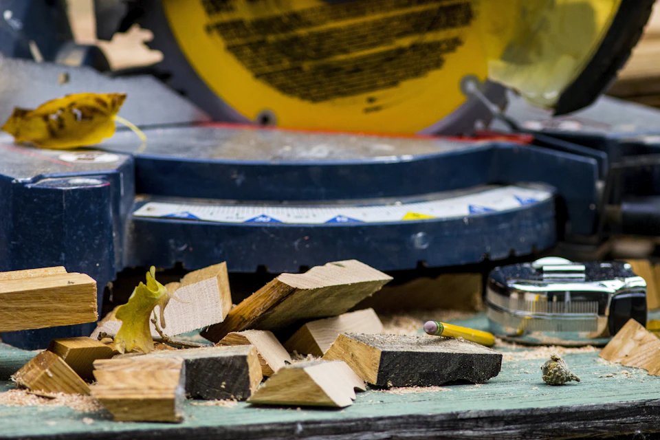 Miter saw on a workbench with wood offcuts and measuring tools